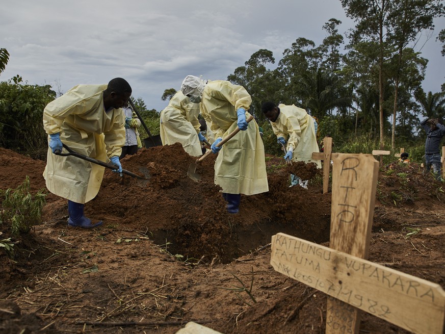 epaselect epa07802952 Health workers fill in the grave of an Ebola victim Kakule Mbusa Desire, in Beni, North Kivu province, Democratic Republic of the Congo, 29 August 2019. Kakule was infected in th ...