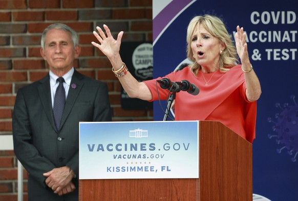 First lady Jill Biden speaks, as White House Chief Medical Adviser Dr. Anthony Fauci listens, at a drive-thru COVID-19 vaccination site at Osceola Community Health Services in Kissimmee, Fla., on Thur ...