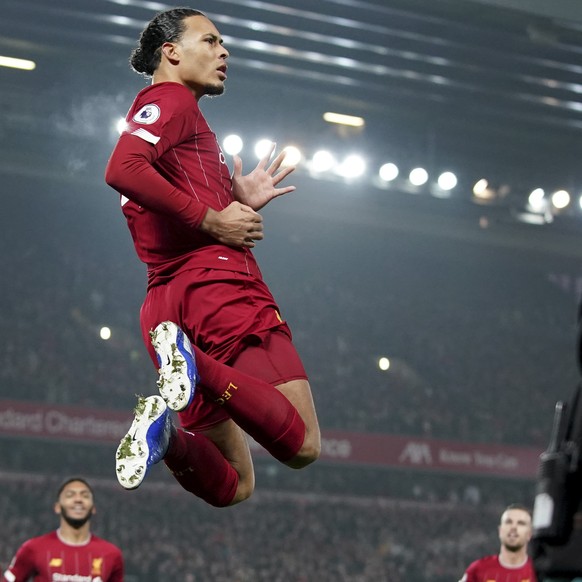 Liverpool&#039;s Virgil van Dijk jumps to celebrate scoring his side&#039;s first goal during the English Premier League soccer match between Liverpool and Manchester United at Anfield Stadium in Live ...