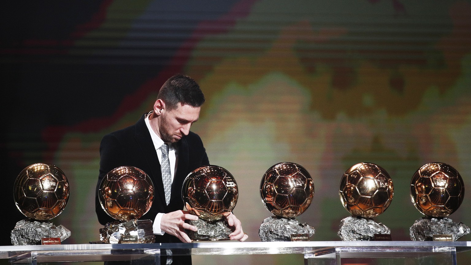 epaselect epa08040259 The Men&#039;s 2019 Ballon d&#039;Or winner Barcelona forward Lionel Messi stands behind his six Ballon d&#039;Or trophies during the ceremony at Theatre du Chatelet in Paris, Fr ...