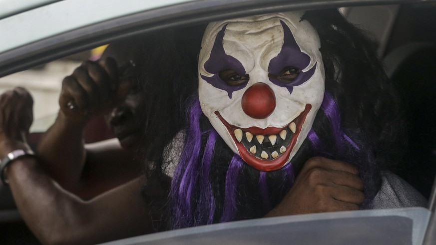 A passenger sits in a car wearing a mask, which he said was to prevent him catching the new coronavirus, in Lagos, Nigeria Friday, March 27, 2020. The new coronavirus causes mild or moderate symptoms  ...