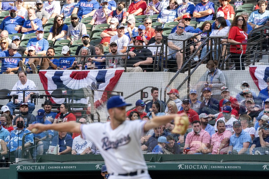 Texas Rangers fans watch relief pitcher Kyle Cody work against the Toronto Blue Jays during the seventh inning of a baseball game Monday, April 5, 2021, in Arlington, Texas. (AP Photo/Jeffrey McWhorte ...