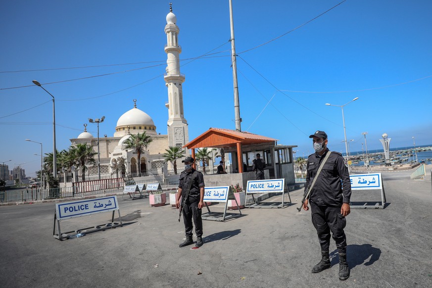 epa08624357 Palestinian Hamas policemen stand guard in a nearly empty street in Gaza City, Gaza Strip, 25 August 2020. The Gaza Strip is under a nationwide lockdown after the discovery of the first ca ...