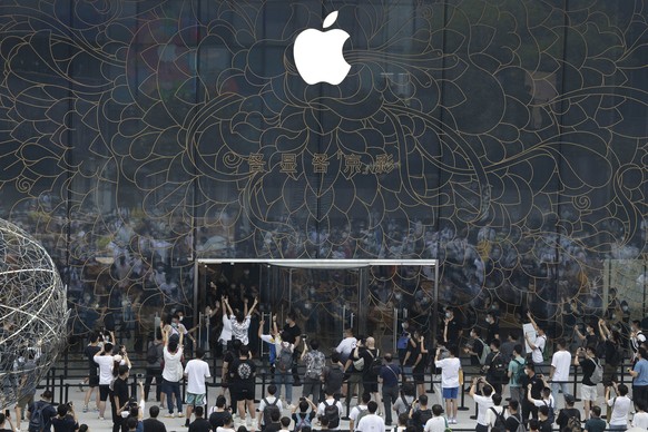 Apple fans cheer as the doors to a new flagship store are opened at Sanlitun in Beijing, China on Friday, July 17, 2020. China&#039;s economy rebounded from a painful contraction to grow by 3.2% over  ...