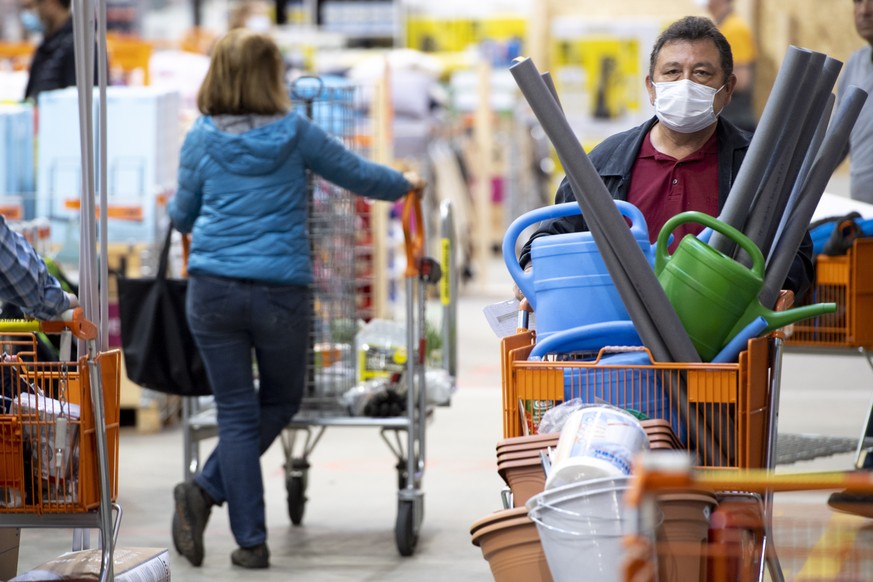 epa08386332 Customers wearing protective face mask make purchases on the first day of the reopening of the DIY-store offering home improvement and do-it-yourself goods Hornbach during the state of eme ...