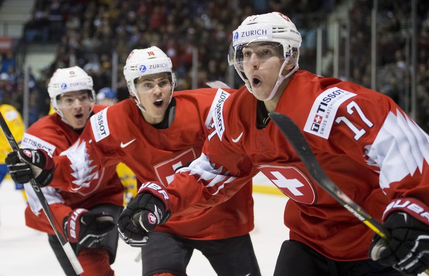 Switzerland&#039;s Luca Wyss, right, celebrates his goal past Sweden with teammates Sandro Schmid and Matthew Verboon during the second period of a world junior hockey championships game in Victoria,  ...