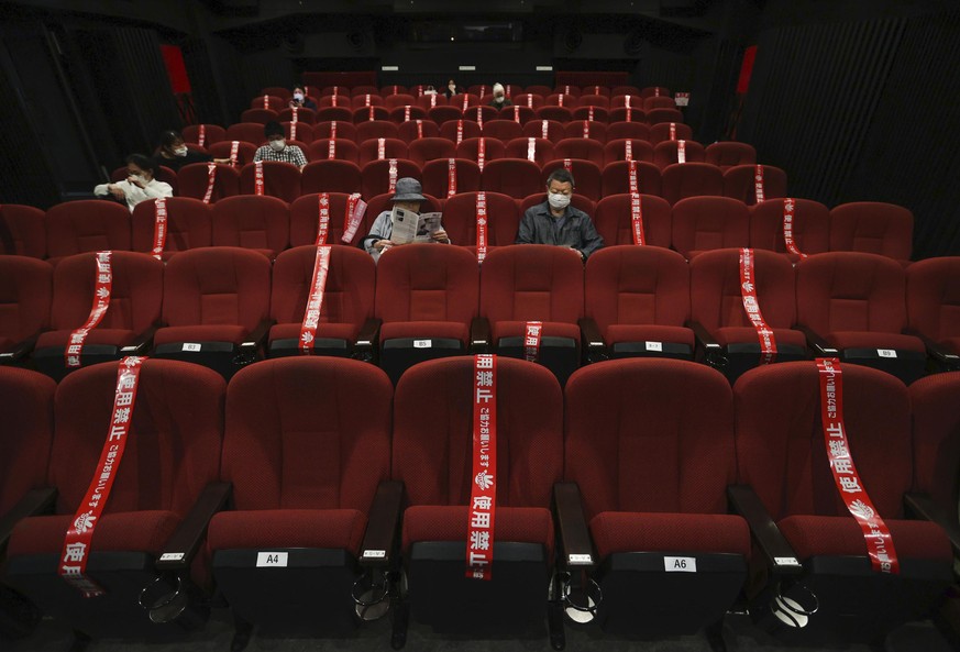 CORRECTS SLUG: Red tape blocks off some seats in an attempt to promote social distancing at a movie theater which reopened on May 22, in Kyoto, western Japan, Saturday, May 23, 2020. Japan has lifted  ...