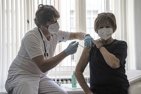 Patient Nicole Brusselaers, right, is vaccinated against the coronavirus with the Pfizer vaccine by family doctor Karl Schorn, left, in Berlin, Germany, Thursday, April 8, 2021. (Paul Zinken/dpa via A ...