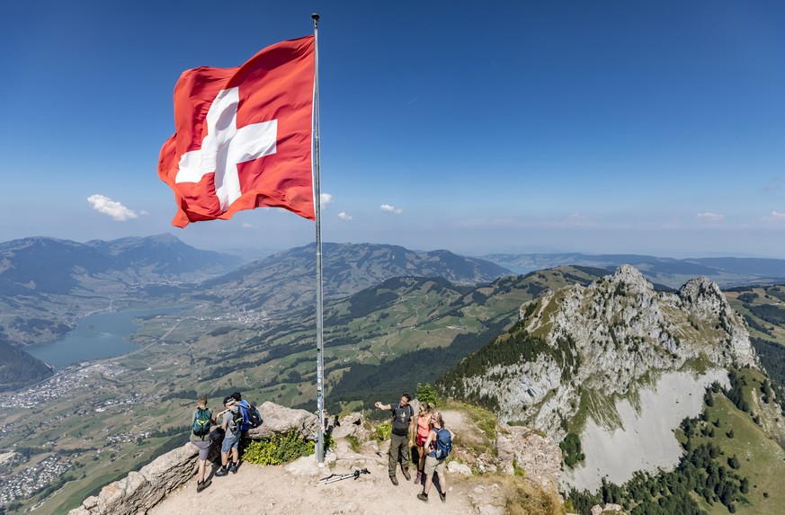 Wanderer auf dem Grossen Mythen oberhalb von Brunni stehen unter einer Schweizer Fahne am Samstag, 4. August 2018. Bis zu 40&#039;000 Menschen wandern jedes Jahr auf den Berg. Auch auf 1898 Meter uebe ...