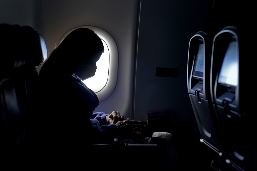 A passenger wears a face mask she travels on a Delta Airlines flight Wednesday, Feb. 3, 2021 after taking off from Hartsfield-Jackson International Airport in Atlanta. (AP Photo/Charlie Riedel)