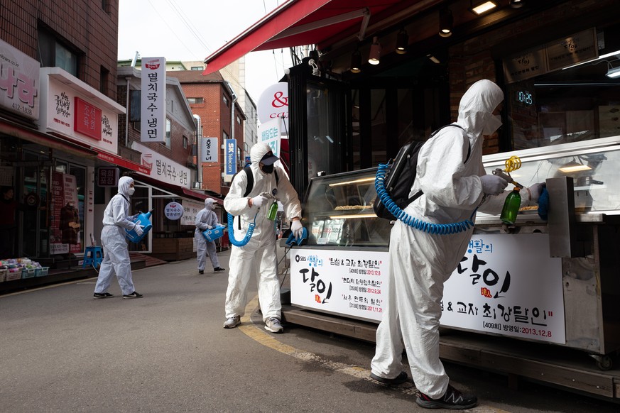 epa08248135 Workers spray disinfectant as a precaution against COVID-19 at Saemaeul traditional market in Seoul, South Korea, 26 February 2020. According to the Korea Center for Disease Control and Pr ...