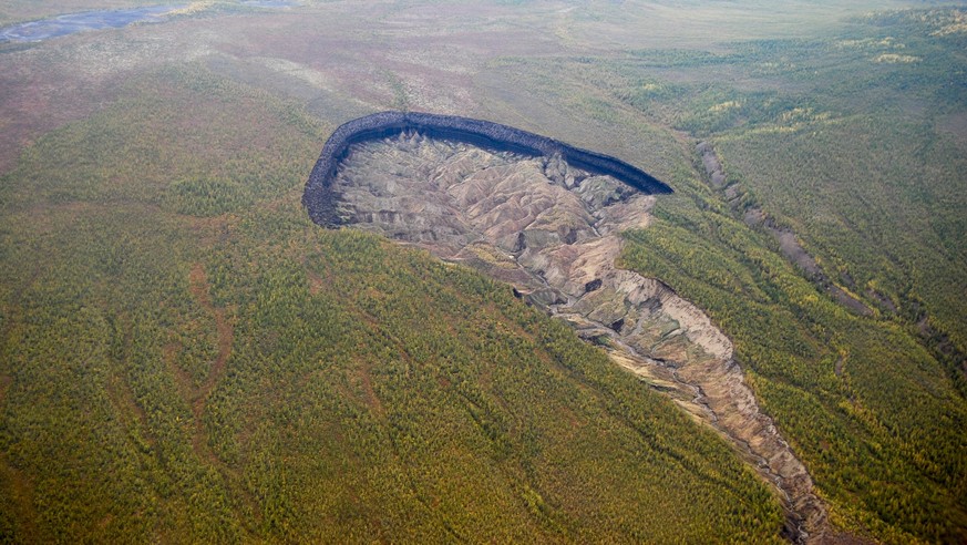 This Tuesday, Aug. 2, 2014 photo provided by the North-Eastern Federal University, shows an air view of the Batagaika crater, a huge 100-meter (328-foot) deep depression in the East Siberian taiga, 66 ...