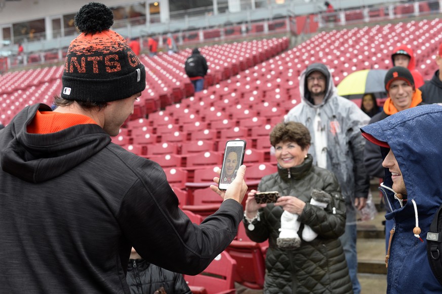 San Fransisco Giants pitcher Cory Gearrin, left, talks via FaceTime at the request of a fan during a rain delay of a San Francisco Giants and Cincinnati Reds baseball game Friday, May 5, 2017, in Cinc ...