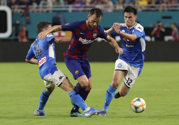 Barcelona&#039;s Ivan Rakitic, center, goes for the ball as Napoli&#039;s Dries Mertens (14) and Nikita Contini (12) defend during the first half of a soccer match Wednesday, Aug. 7, 2019, in Miami Ga ...