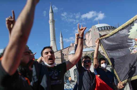 epa08538998 Turkish people hold Turkish national and Ottoman flags in front of the Hagia Sophia Museum, in Istanbul, Turkey, 10 July 2020. Turkey&#039;s highest administration court on 10 July 2020 ru ...