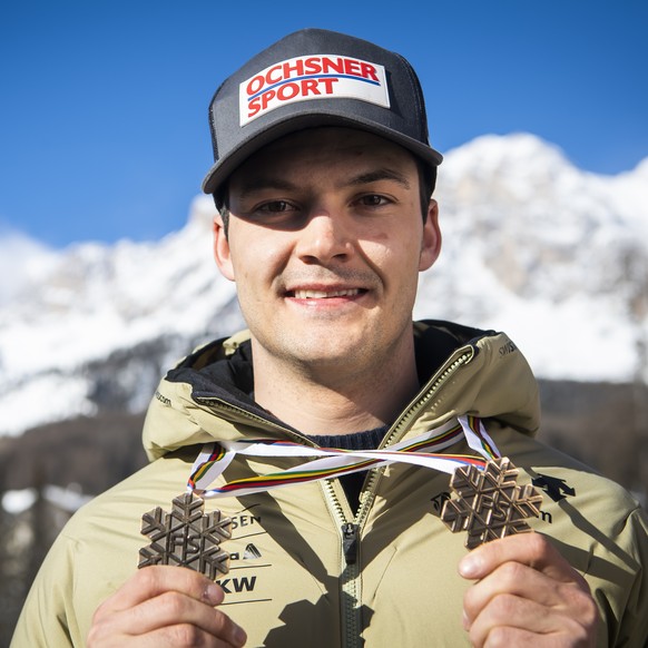 Loic Meillard of Switzerland poses with the Bronze medal for Parallel race and the Bronze medal for Alpine Combined race at the 2021 FIS Alpine Skiing World Championships in Cortina d&#039;Ampezzo, It ...