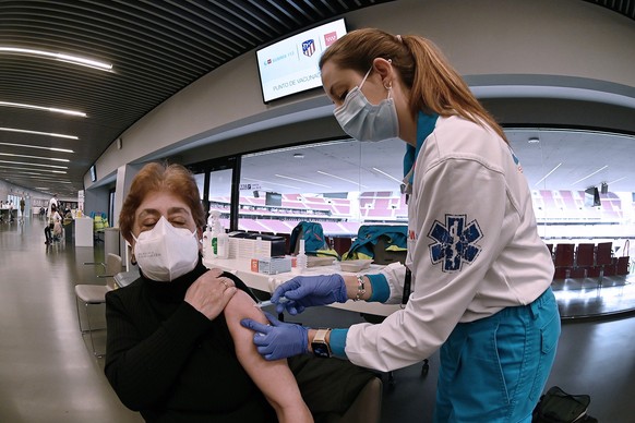 epa09106117 A woman is vaccinated against COVID-19 at Wanda Metropolitano Stadium in Madrid, Spain, 30 March 2021. Spanish people aged from 60 to 65 began to get vaccinated with the AstraZeneca vaccin ...