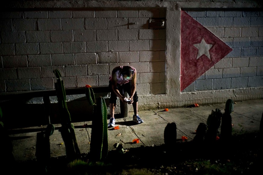 Lazaro Rodriguez, 42, connects his cellphone at a public internet hot spot at night in Havana, Cuba on Saturday, April 14, 2018. Lazaro, who studied baking and is currently working in maintenance, sai ...