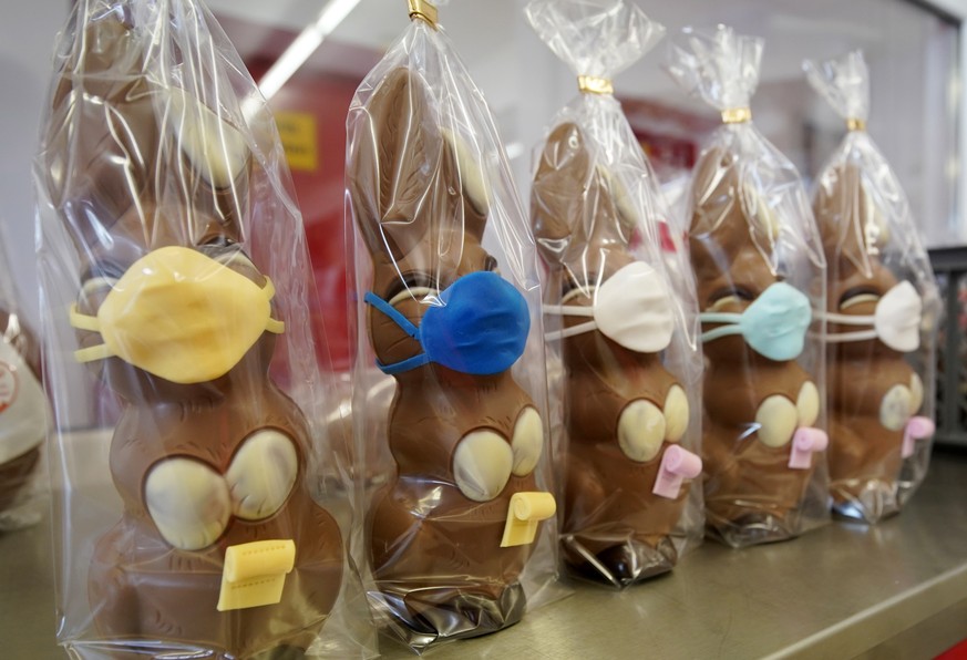 epa08350057 A view of chocolate Easter bunnies with mouth masks during the production at the Wawi company in Pirmasens, Germany, 08 April 2020. WAWI-Schokolade AG is a German company in the confection ...