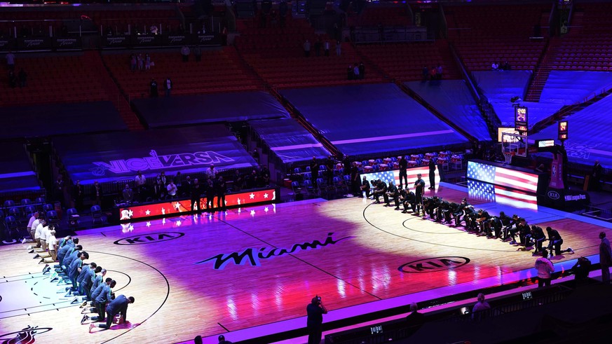 The Boston Celtics and the Miami Heat teams kneel during the playing of the National Anthem before the start of an NBA basketball game, Wednesday, Jan. 6, 2021, in Miami. (AP Photo/Marta Lavandier)