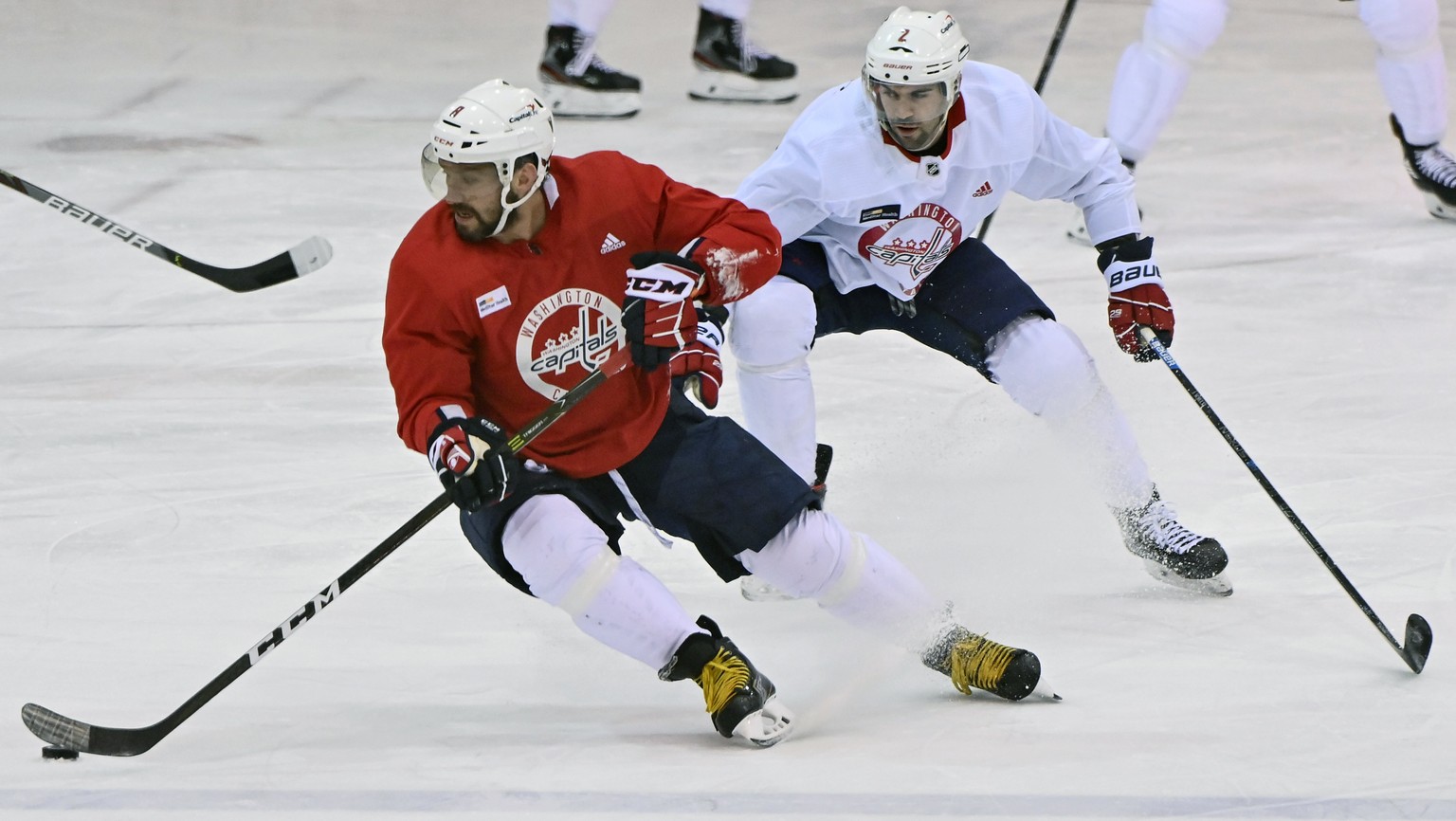 Washington Capitals left wing Alex Ovechkin (8), foreground, runs a play as defenseman Justin Schultz (2) defends during NHL hockey practice at the MedStar Capitals Iceplex in Arlington, Va., Tuesday, ...
