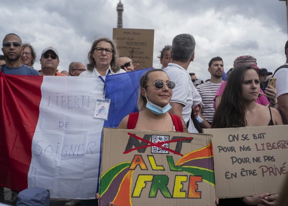 Thousands of protesters gather at Place Trocadero near the Eiffel Tower attend a demonstration in Paris, France, Saturday July 24, 2021, against the COVID-19 pass which grants vaccinated individuals g ...