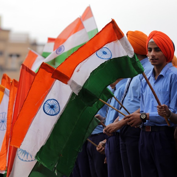 epa07500699 Students hold Indian flags as they take part in an event held to pay tribute to the martyrs of the Jallianwala Bagh Massacre on the eve of massacre&#039;s 100th anniversary, near the Jalli ...