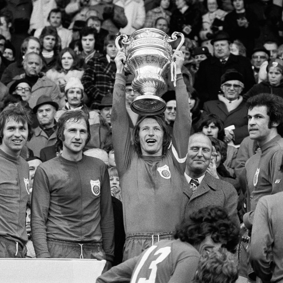 Der FC Basel gewinnt den Cupfinal 1975 gegen den FC Winterthur und wird Schweizer Cupsieger. Der Basler Captain Karl Odermatt streckt den Pokal in die Hoehe, links von ihm stehen Wenger und Stohler, r ...