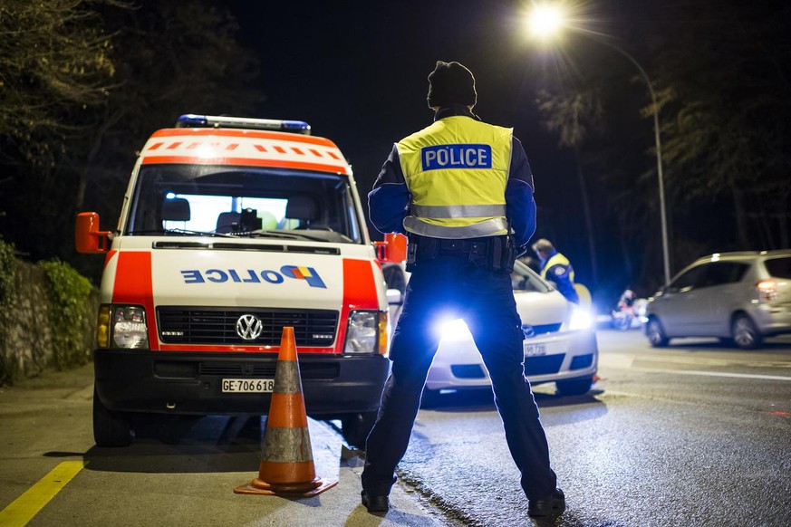 Des policiers controlent des automobilistes lors d&#039;un controle de circulation comprenant la police et la gendarmerie genevoise et vaudoise ainsi que les gardes frontieres ce mardi soir 23 decembr ...
