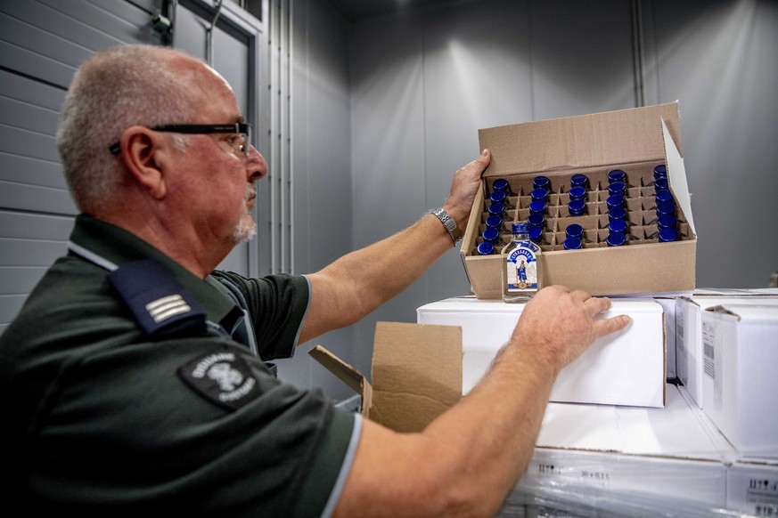 epa07398395 An officer of the customs authorities in the port of Rotterdam presents a box with bottles of vodka, in Rotterdam, The Netherlands, 26 February 2019, after a container with 90,000 bottles  ...