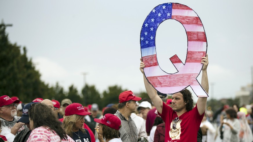 FILE - In this Aug. 2, 2018, file photo, David Reinert holding a Q sign waits in line with others to enter a campaign rally with President Donald Trump in Wilkes-Barre, Pa. A far-right conspiracy theo ...
