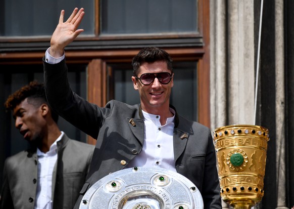 epa07602769 Bayern&#039;s Robert Lewandowski waves behind the German Bundesliga championship trophy and the the DFB Cup trophy during the celebration of FC Bayern Munich winning German championship an ...