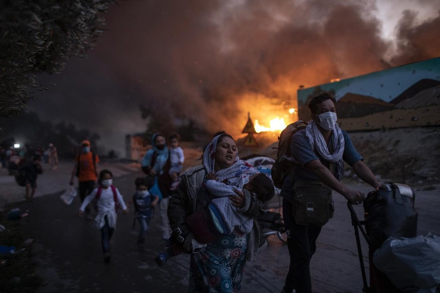 Migrants flee from the Moria refugee camp during a second fire, on the northeastern Aegean island of Lesbos, Greece, on Wednesday, Sept. 9, 2020. Fire struck again Wednesday night in Greece&#039;s not ...