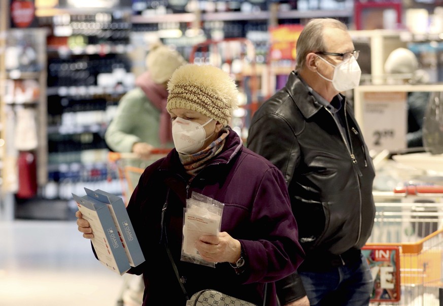People wear an FFP2 protective mask when shopping in a supermarket in Vienna, Austria, Monday, Jan. 25, 2021. Austrians have to use medical masks when shopping and in public transport, as masks have b ...