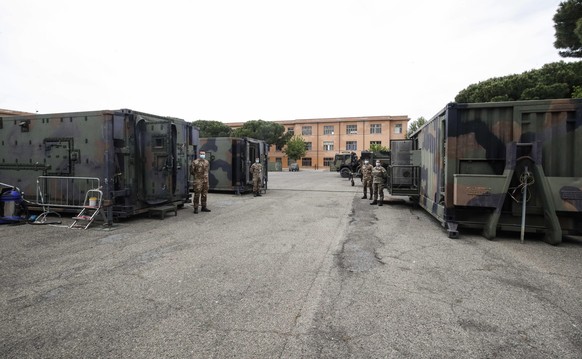 epa08428544 Soldiers pose outside containers of a biological field laboratory of the Italian 7th CBRN Defense Regiment &#039;Cremona&#039;, set up as they are deployed to sanitized health facilities i ...