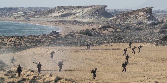 In this photo provided by Tasnim News Agency, Iran&#039;s Revolutionary Guard members walk on the coast during a drill around Qeshm Island, Iran, Saturday, Dec. 22, 2018. State TV is reporting that Ir ...