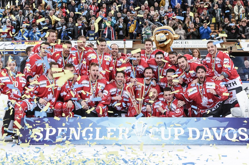 Team Canadas players celebrate with the trophy after winnig the final game between Team Canada and Team Suisse at the 91th Spengler Cup ice hockey tournament in Davos, Switzerland, Sunday, December 31 ...