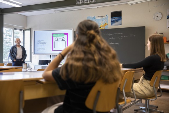 Ein Lehrer erklaert den Schuelern in einem Klassenzimmer des Schulzentrums Schlossmatt die Verhaltensregeln im Zusammenhang mit dem Coronavirus, am Montag, 11. Mai 2020 in Muensingen. Nach weiteren Lo ...