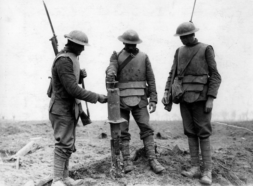 31 Juli 1917, «Dritte Flandernschlacht» im&nbsp;Raum Ypern:&nbsp;Irische Soldaten tragen erbeutete deutsche Grabenpanzer und untersuchen ein gefundenes Maschinengewehr.