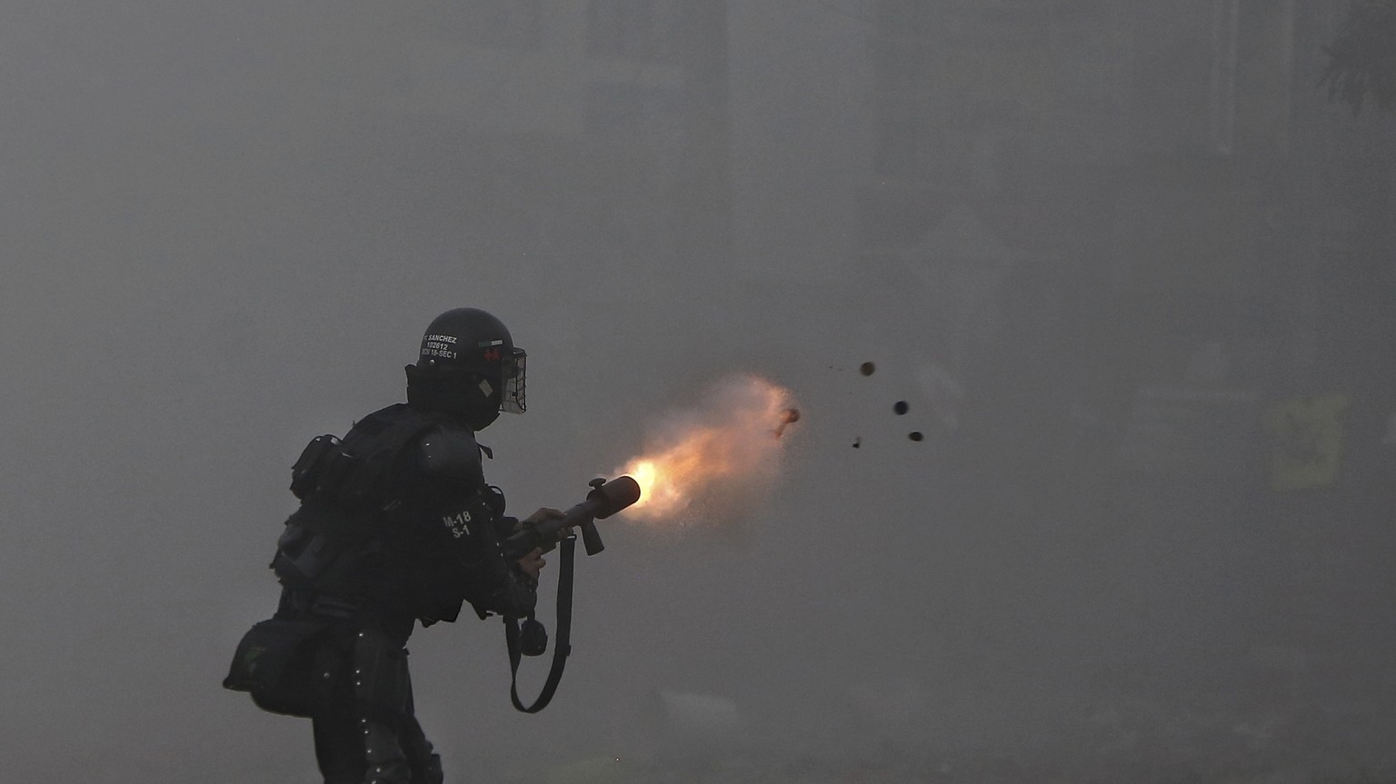 A police officer fires tear gas at protesters during a strike against tax reform in Cali, Colombia, Monday, May 3, 2021. Colombia&#039;s President Ivan Duque withdrew the government-proposed tax refor ...