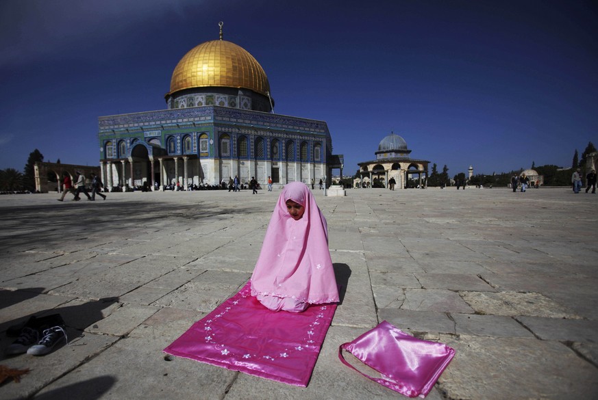 The Dome of the Rock Mosque is seen in the background as a young Palestinian Muslim worshipper prays during Friday noon prayer in the Al Aqsa Mosque compound in Jerusalem&#039;s Old City, Friday, Jan. ...