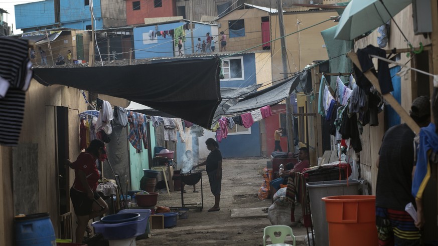 A woman cooks outside her house in a shanty town of Lima, Peru, Thursday, April 2, 2020. As the new coronavirus pandemic hits Peru, President Martin Vizcarra declared a state of emergency as deaths be ...