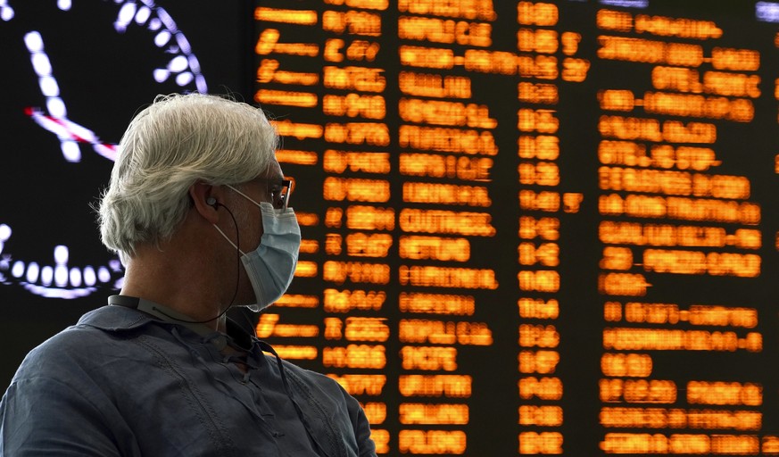 A traveler wears a mask as he waits inside Rome&#039;s Termini train station, Tuesday, March 10, 2020. In Italy the government extended a coronavirus containment order previously limited to the countr ...