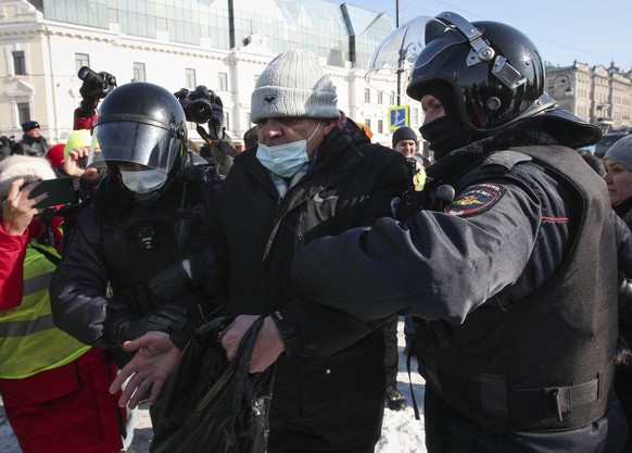 Police officers detain a man during a protest against the jailing of opposition leader Alexei Navalny in Vladivostok, Russia, on Sunday, Jan. 31, 2021. As part of a multipronged effort by the authorit ...