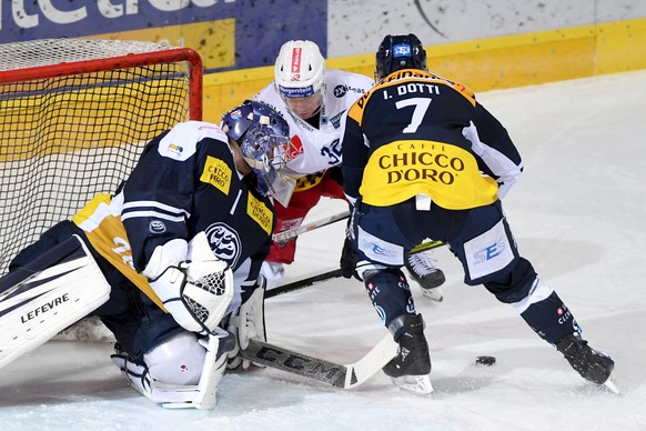 Ambri&#039;s goalkeeper Benjamin Conz, Laker&#039;s player Kevin Clark and Ambri&#039;s player Isacco Dotti, from left, fight for the puck, during the preliminary round game of National League Swiss C ...