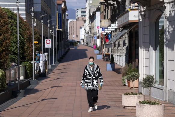 Eine Frau mit Mundschutz auf einer leeren Strasse aufgrund der Coronavirus Pandemie aufgenommen am Montag, 16. Maerz 2020 in Chiasso. (KEYSTONE/Ti-Press/ Davide Agosta)