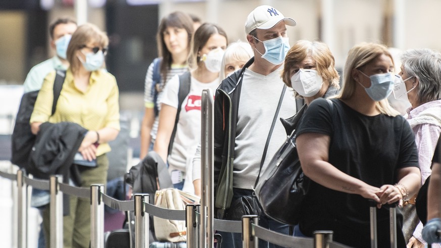 Fluggaeste warten mit Atemschutzmasken vor einem Check-In Schalter aufgenommen anlaesslich des Schutzkonzeptes vom Flughafen Zuerich, aufgenommen am Donnerstag, 28. Mai 2020 in Zuerich. (KEYSTONE/Enni ...