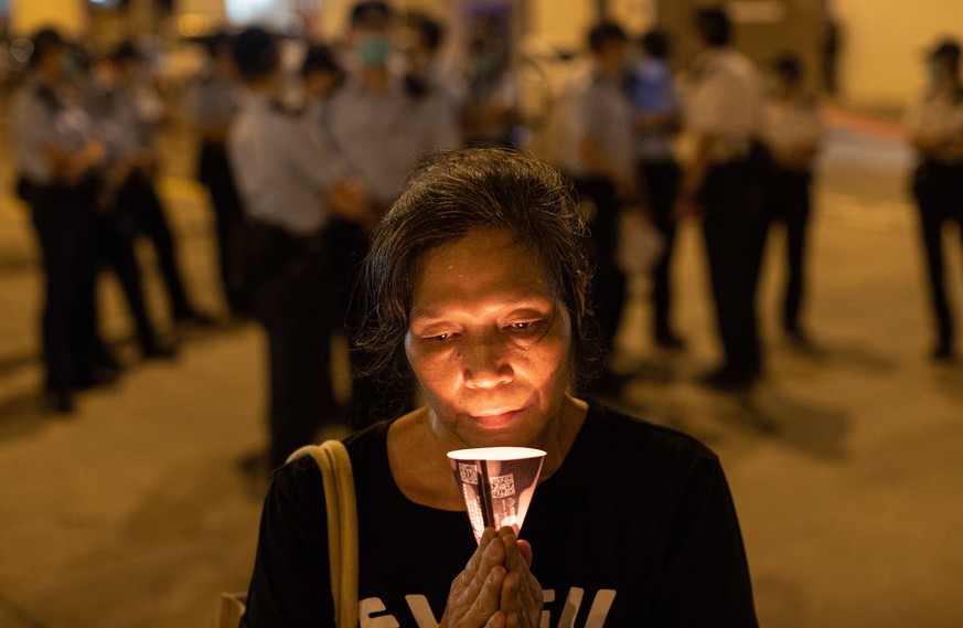 epa08462703 A woman holds a candle on the eve of the Beijing Tiananmen Massacre anniversary near the Lai Chi Kok Reception Centre in Hong Kong, China, 03 June 2020. The participants commemorated the T ...