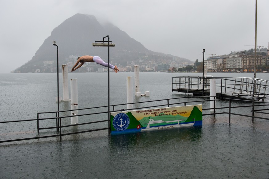 Ein junger Mann (Nicolas Realini, 35) springt bei starkem Regen in den Lungolago von Lugano, am Samstag, 15. November 2014. Das Tessin kommt nicht zur Ruhe. Nach einer kurzen Verschnaufpause hat in de ...