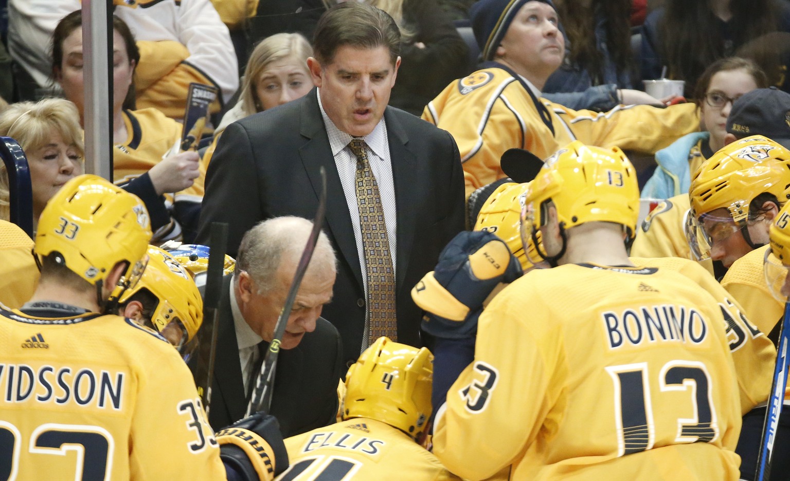 FILE - In this Dec. 29, 2018, file photo, Nashville Predators coach Peter Laviolette, center, and associated coach Kevin McCarthy, center left, talk to players during a timeout in an NHL hockey game a ...